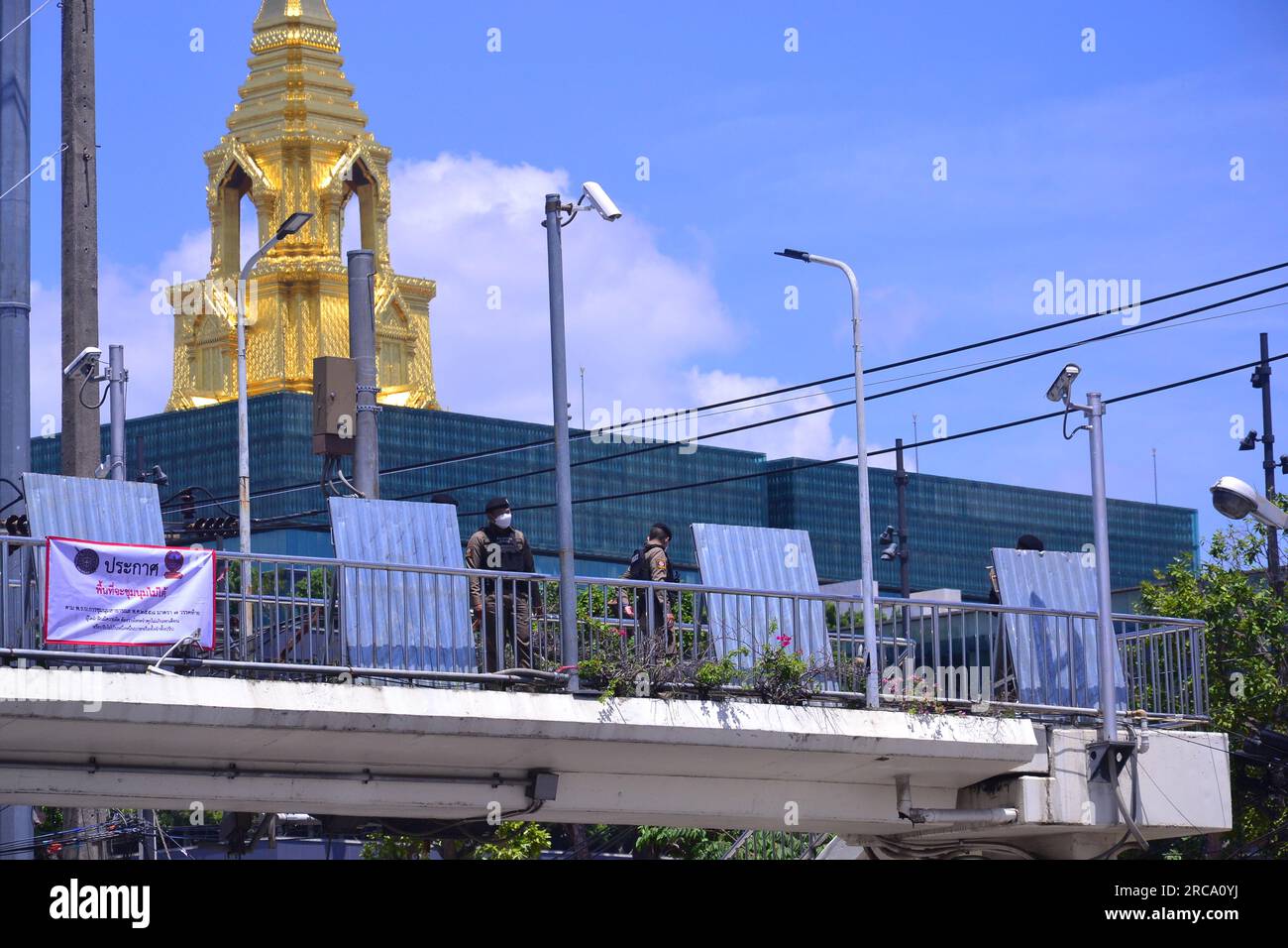 Das Parlamentsgebäude in Bangkok, Thailand, wird von Polizeibeamten geschützt, die auf einem Fußweg mit Barrieren stehen, Stunden vor einem Protest demokratiefreundlicher Anhänger der Move Forward Party. Das thailändische Parlament stimmt am 13. Juli ab, um zu entscheiden, ob die Anführerin der Partei Move Forward, Pita Limjaroenrat, die bei den Wahlen im Mai die meisten Sitze gewonnen hat, die neue Premierministerin werden kann. Pita Limjaroenrat verlor die Wahl zum Premierminister, 51 Stimmen weniger als 376 Stimmen. Stockfoto