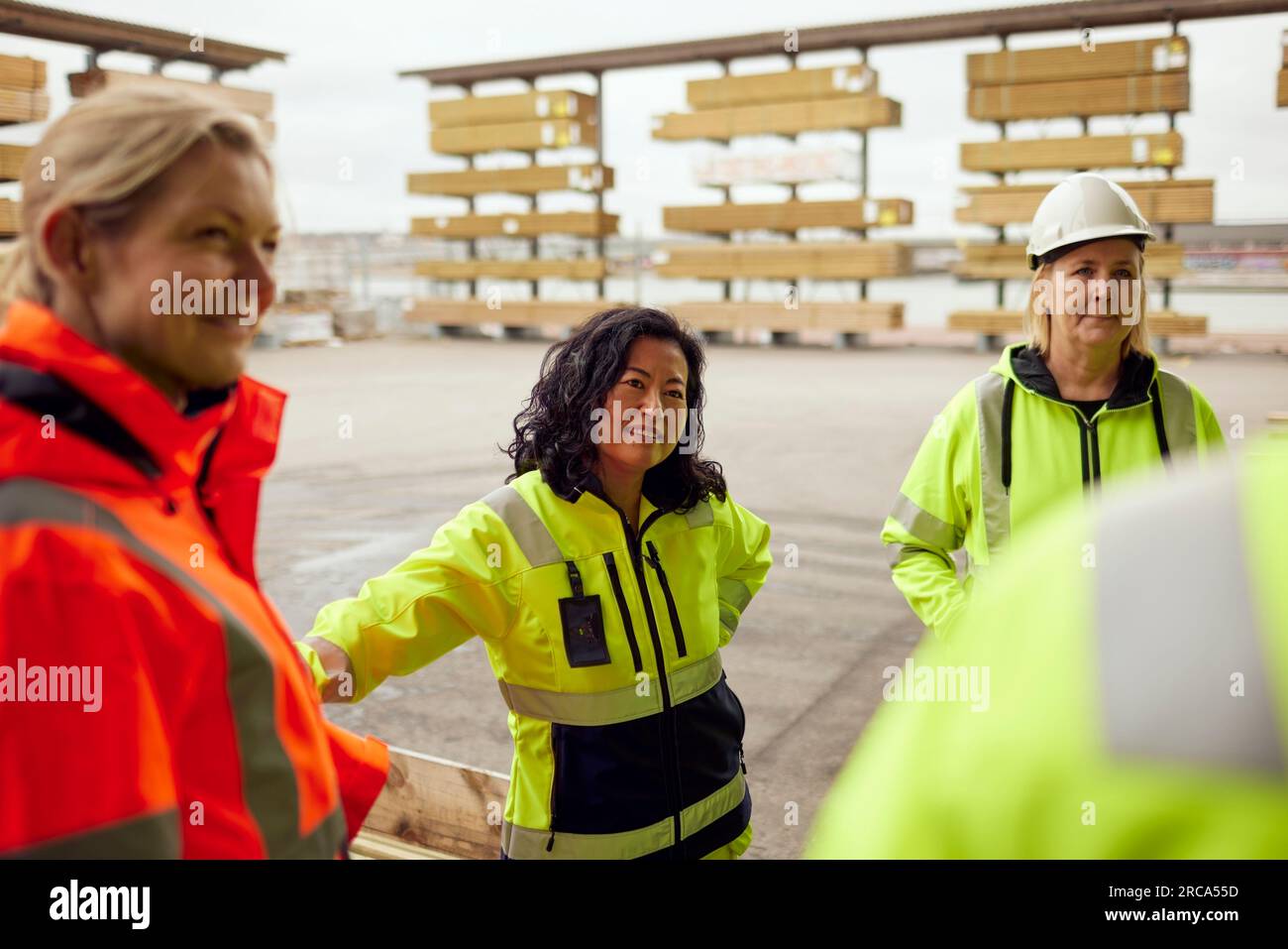 Multirassische Arbeitskollegen in Arbeitsschutzkleidung im Stand in der Fabrik Stockfoto