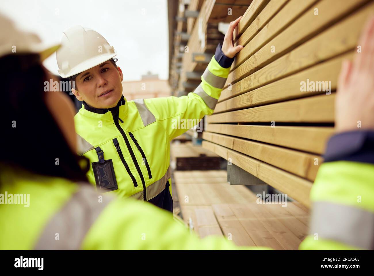 Mehrsprachige Arbeiterinnen, die sich über Planks in der Industrie unterhalten Stockfoto