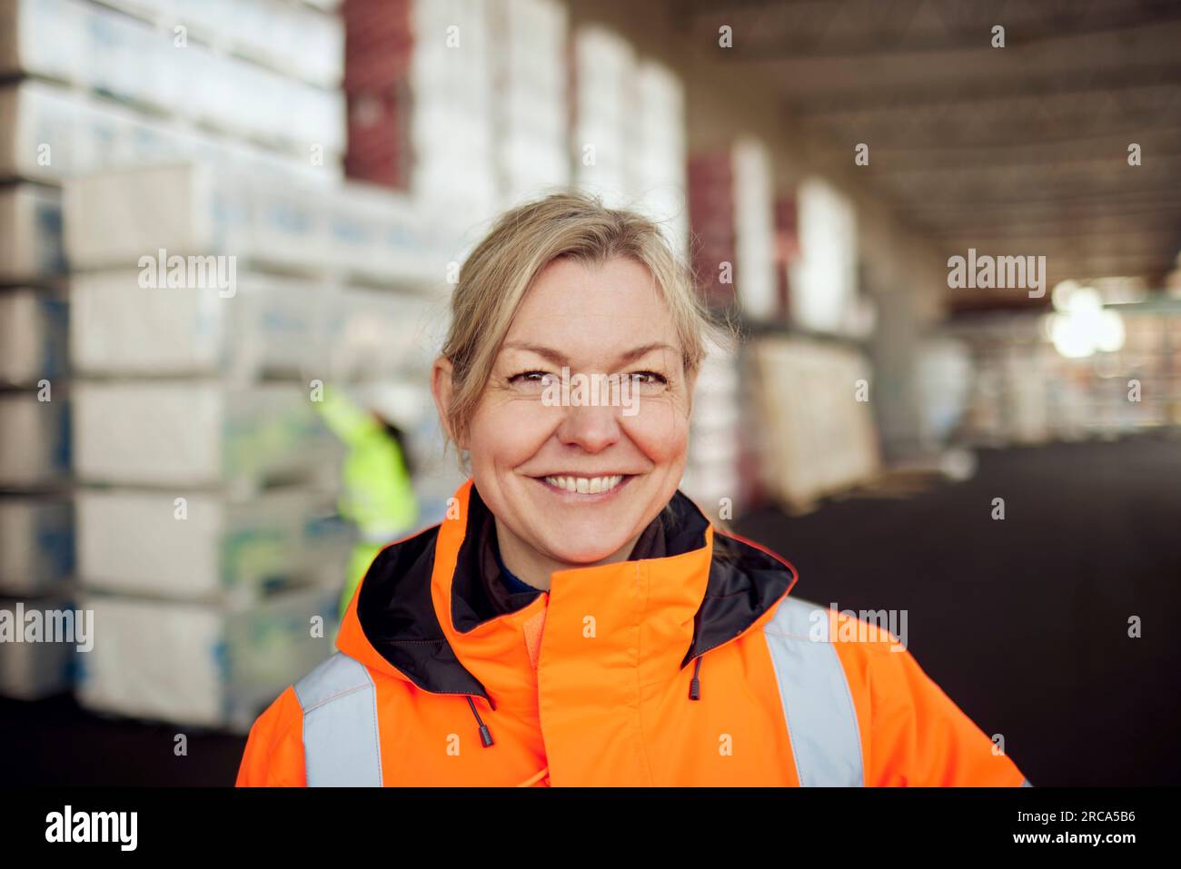 Porträt einer lächelnden Arbeiterin in Arbeitsschutzkleidung in der Industrie Stockfoto