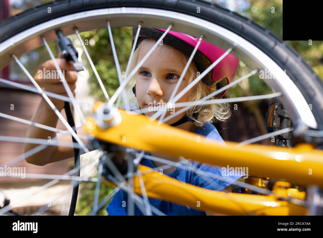 Mädchen benutzt Luftpumpe, um den Fahrradreifen im Freien aufzupumpen. Motorradwartung Stockfoto