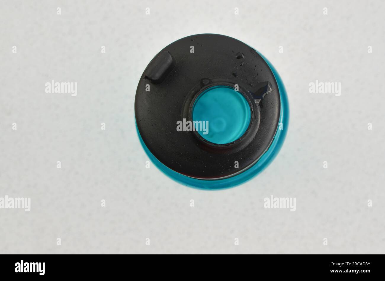 Detail der blauen Wasserflasche, die die Bedeutung der Hydratation im Alltag der Sportler darstellt. Energie und Vitalität in einem einzigen Behälter. Stockfoto