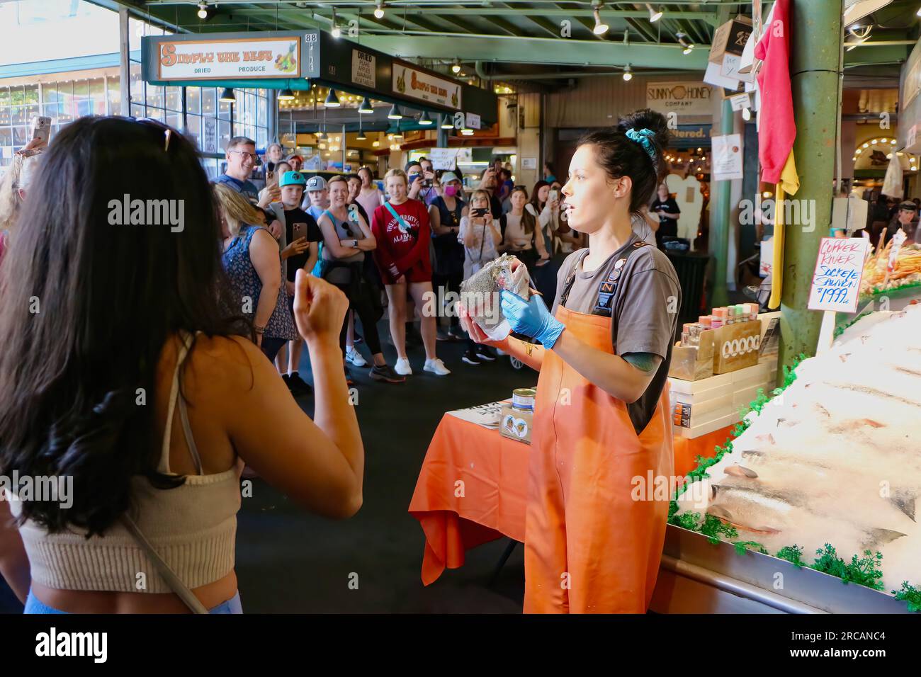 Berühmt für Fisch, der die Käufe von Kunden wirft, bevor er den Pike Place Fish Market Seattle Washington State USA einpackt Stockfoto