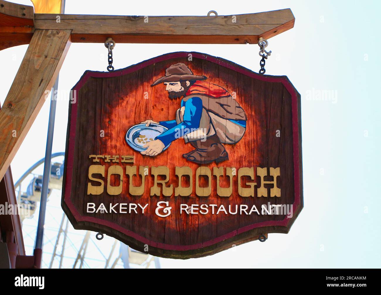 Schildern Sie für das Sourdough Bakery & Restaurant mit einem Mann, der nach dem goldenen Alaska Way Seattle Washington State USA schaut Stockfoto