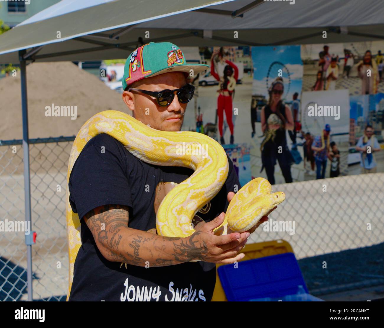 Ein Mann, der eine amelanistische birmanische Python-Bivittatus-Schlange hält, die Touristen bezahlen, um Fotos mit Seattle Washington State USA zu machen Stockfoto