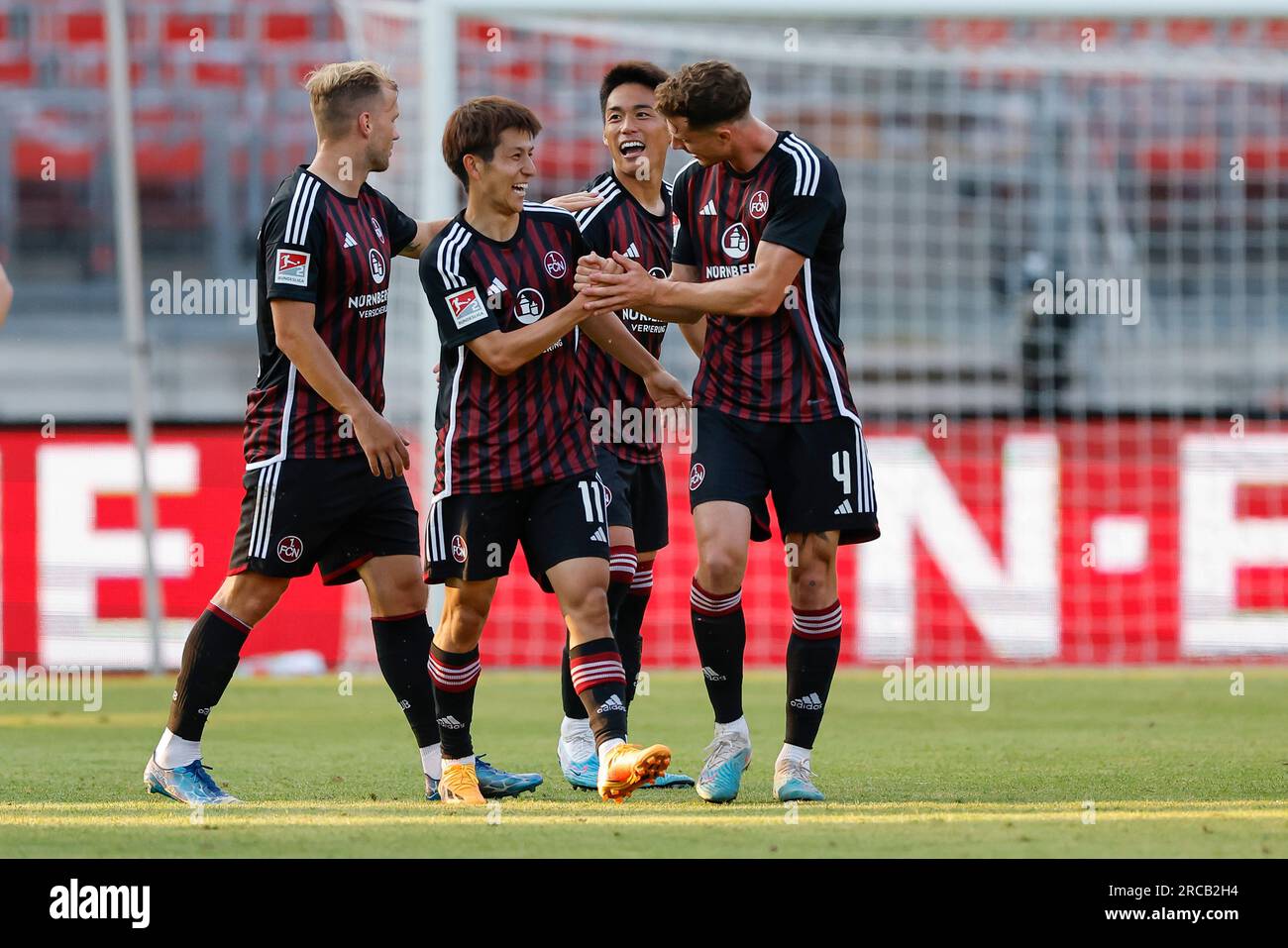 Nürnberg, Deutschland. 13. Juli 2023. - Testspiele, 1. FC Nürnberg – FC Arsenal, Max-Morlock-Stadion, Nürnberg: Nürnbergs Nathaniel Brown (l-r), Kanji Okunuki, Daichi Hayashi und James Lawrence feiern Okunikis Ziel, es um 1:1 Uhr zu schaffen. Kredit: Daniel Löb/dpa/Alamy Live News Stockfoto