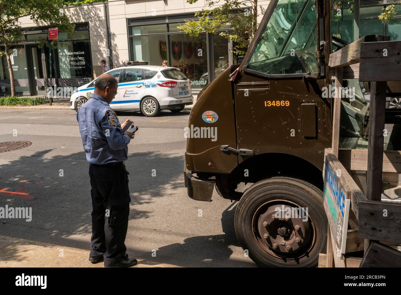 Ein NYPD-Verkehrsagent erstellt am Freitag, den 7. Juli 2023, ein Ticket für einen UPS-Lkw in Chelsea in New York. (© Richard B. Levine) Stockfoto