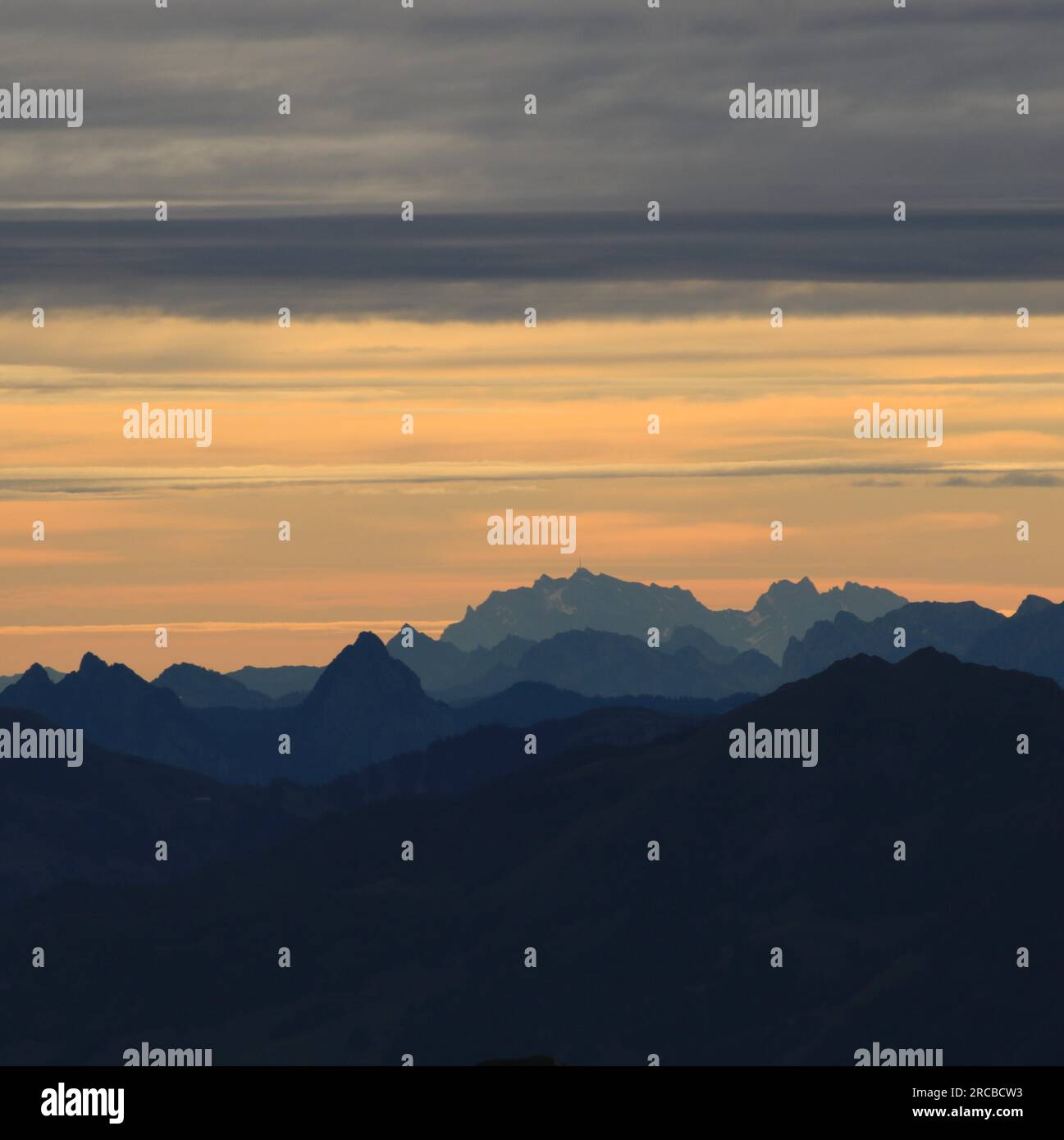 Leuchtend gelber Morgenhimmel über dem Berg Grosser Mythen, Saentis und anderen Bergen in den Schweizer Alpen Stockfoto
