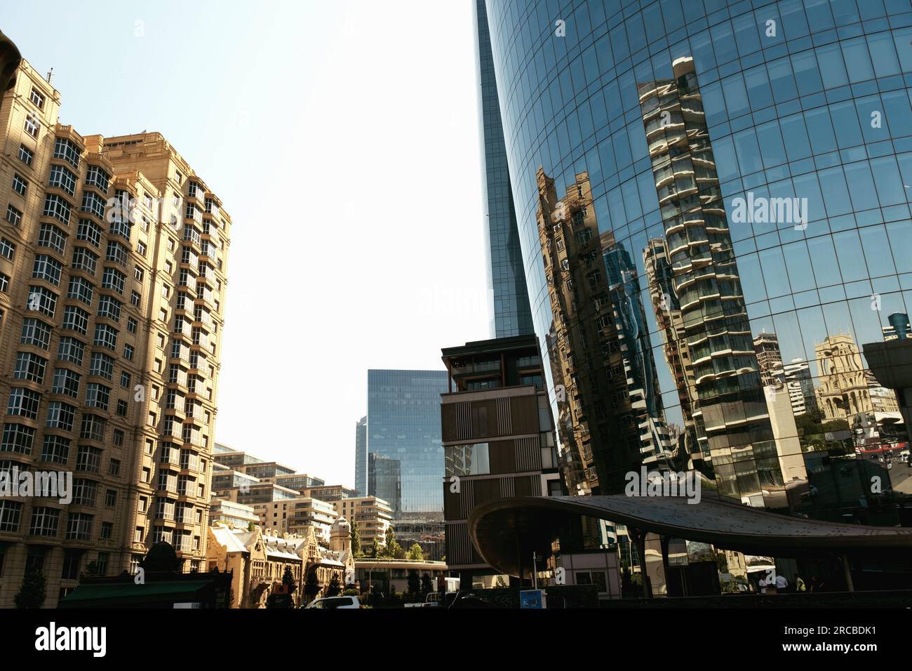 Baku, Aserbaidschan - 26. Juni 2023: Aufnahmen am frühen Morgen, die Bakus historische und moderne Gebäude in den Fenstern eines Wolkenkratzers widerspiegeln Stockfoto