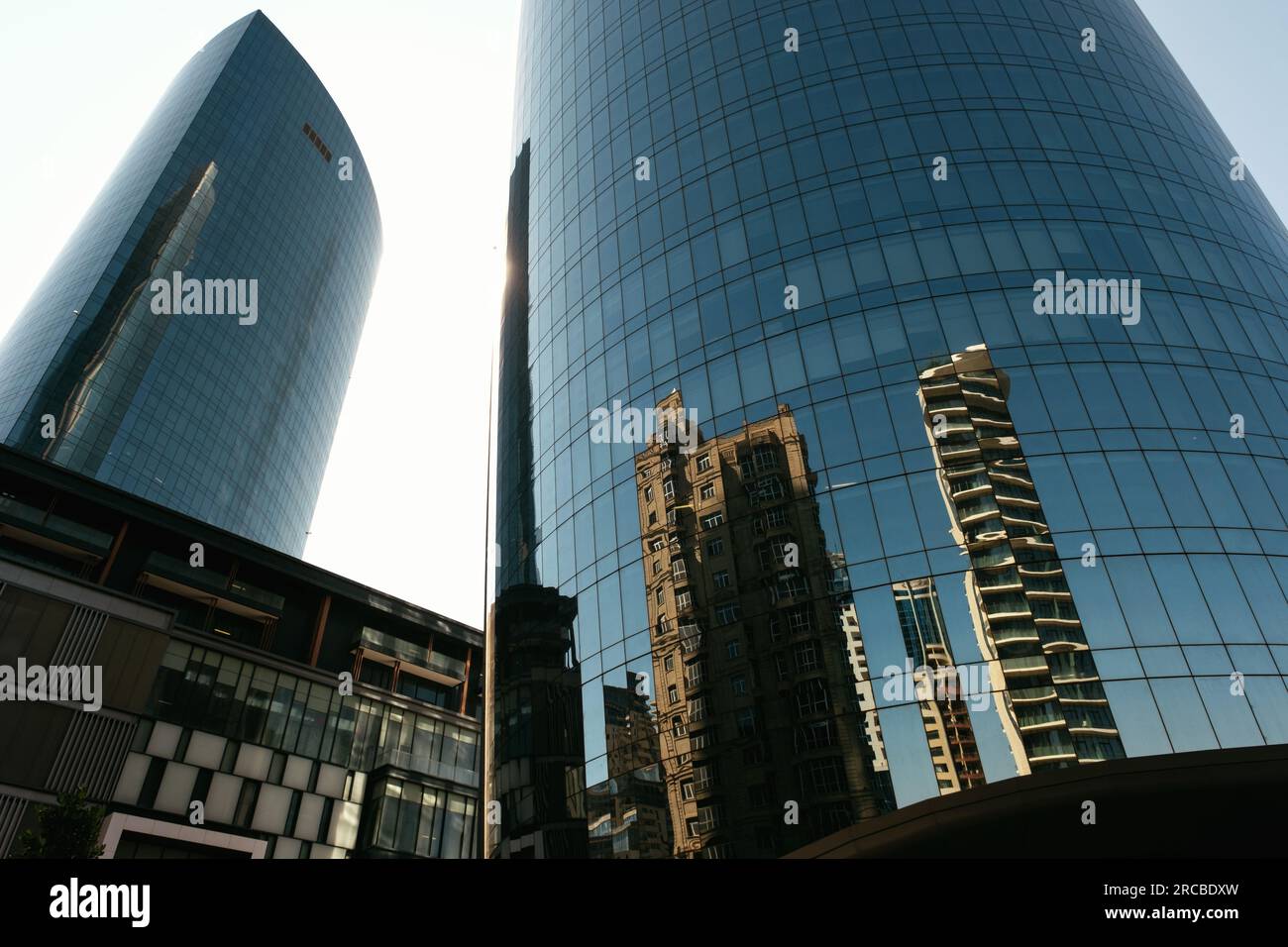 Baku, Aserbaidschan - 26. Juni 2023: Aufnahmen am frühen Morgen, die Bakus historische und moderne Gebäude in den Fenstern eines Wolkenkratzers widerspiegeln Stockfoto