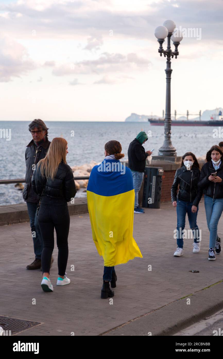 Neapel, Italien - 10. April 2022: Zivilisten, die die Ukraine beim Konflikt mit Russland von 2022 unterstützen, die ukrainische Staatsflaggen außerhalb von Neapel anbinden, Stockfoto