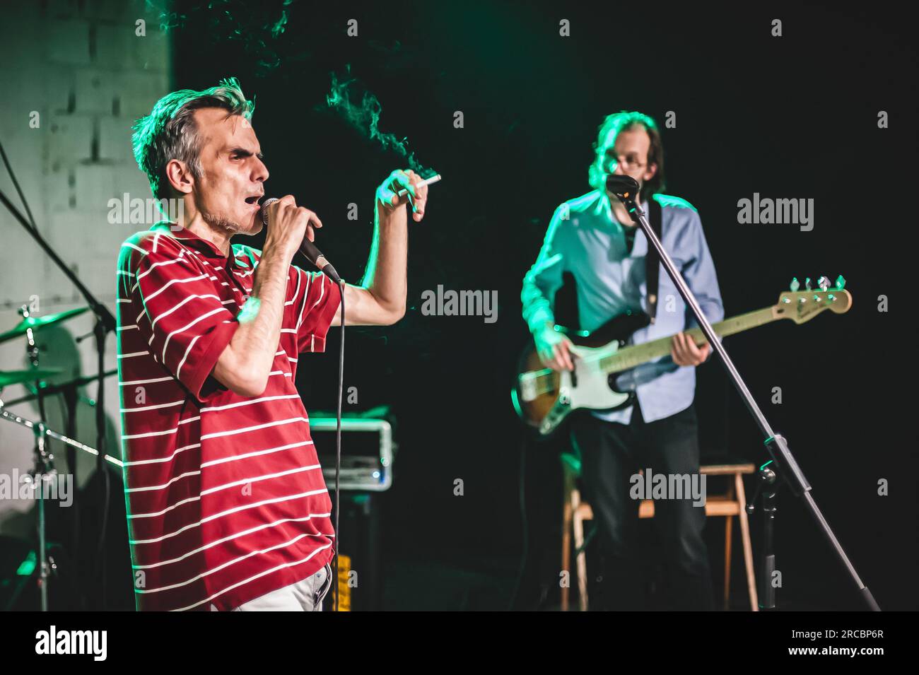 Der Sänger, der Künstler ist, nimmt während einer Live-Aufführung auf einer Bühne ein Porträt auf. Punk-Rock-Musikband-Gruppe Stockfoto