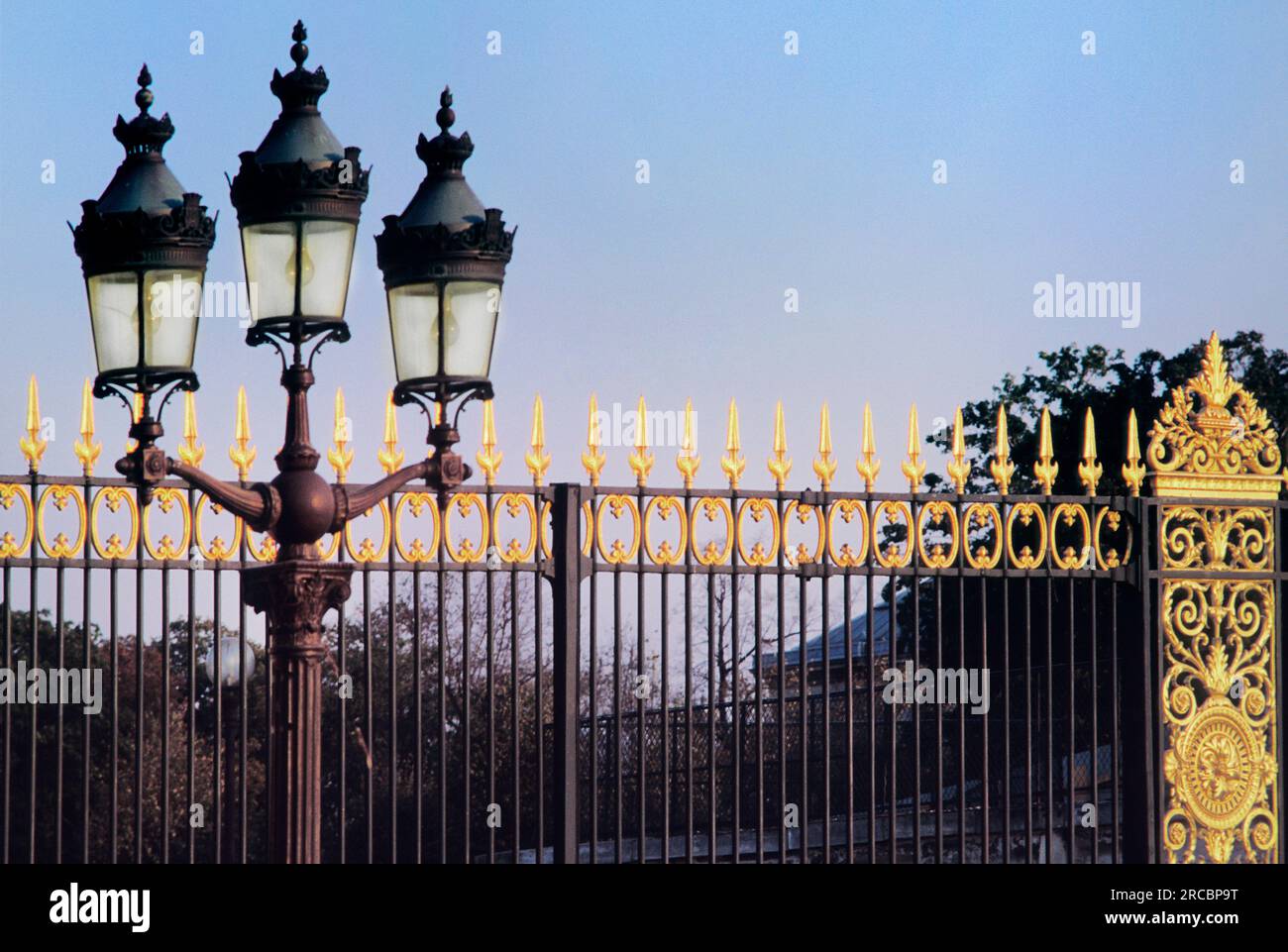 Place de la Concorde, Paris, Frankreich. Historischer Place de la Revolution. Sonnenuntergang über den goldenen Metalltoren der Tuilerien. Alte Straßenlaterne Stockfoto