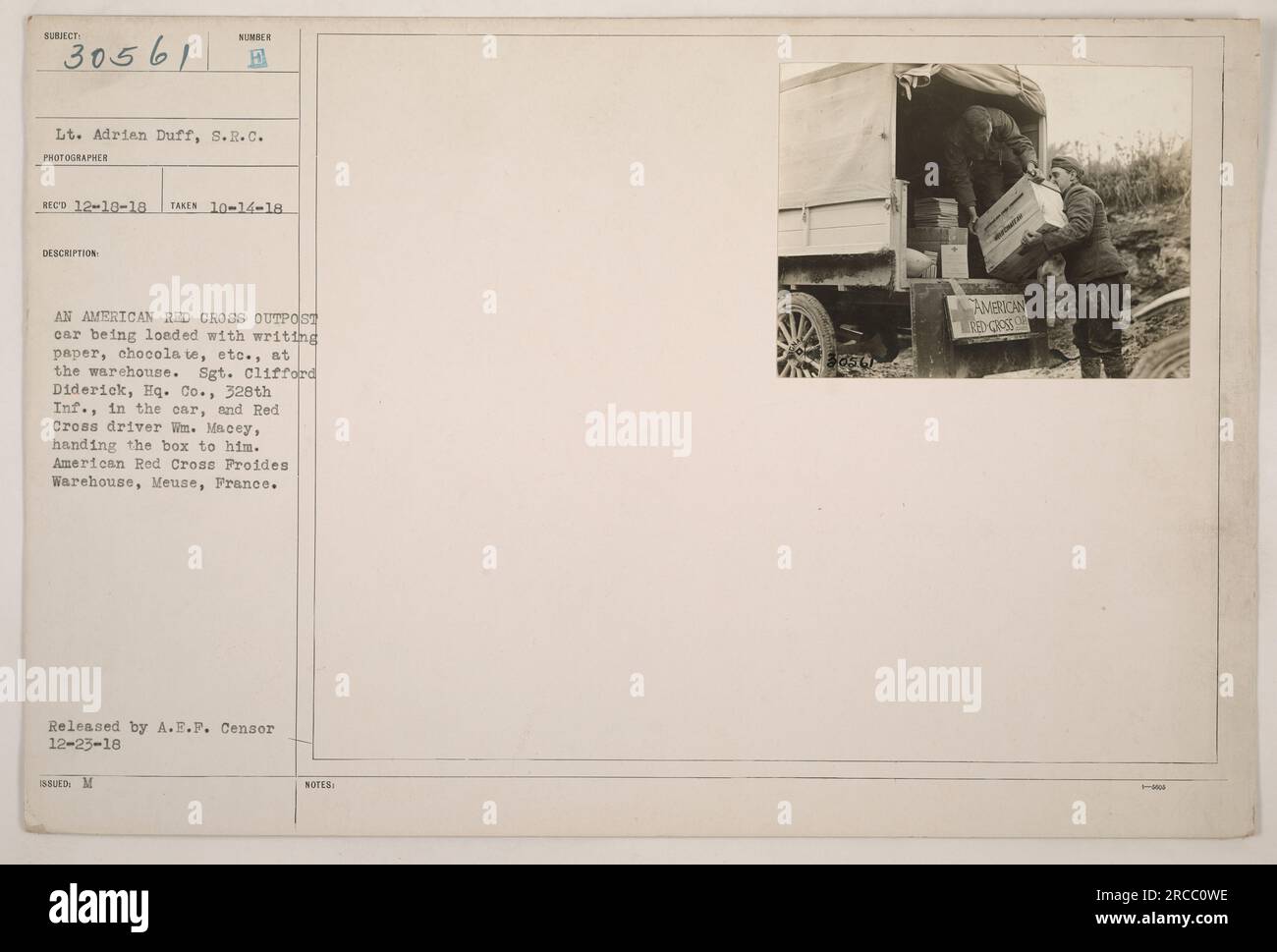 Der Außenposten des amerikanischen Roten Kreuzes wird im Lagerhaus mit Vorräten beladen. Sergeant Clifford Diderick sitzt im Auto, während der Fahrer des Roten Kreuzes WM fährt. Macey gibt ihm eine Schachtel Schreibpapier, Schokolade und andere Dinge. Dieses Foto wurde im American Red Cross Froides Warehouse in Mause, Frankreich, aufgenommen. Veröffentlicht von A.E.F. Censor. Stockfoto