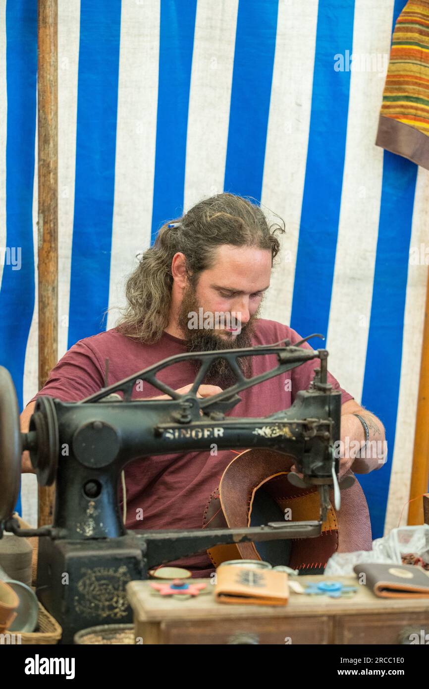 Handwerker, der mit Lederwaren arbeitet, mit einer alten Sängernähmaschine. Stockfoto