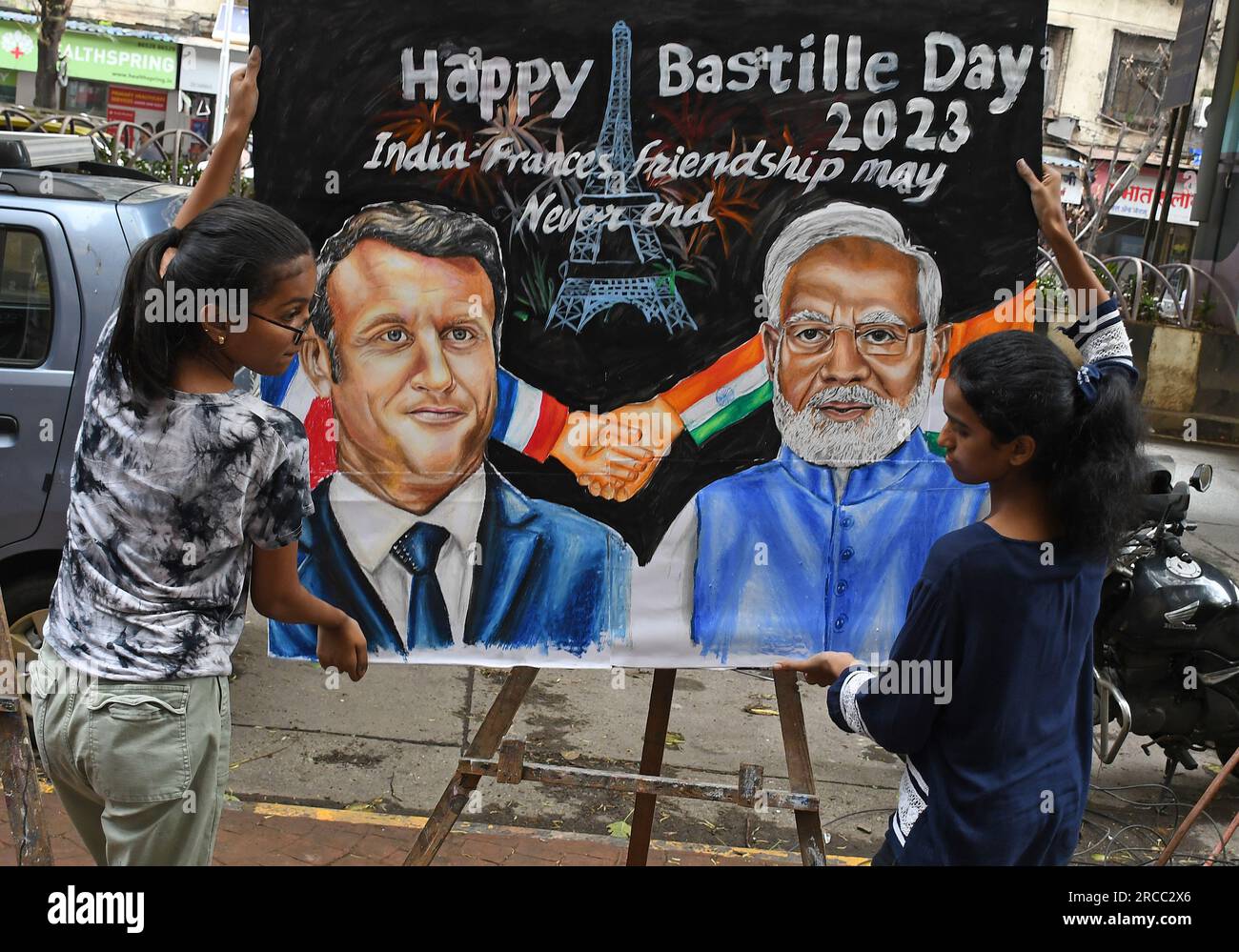 Mumbai, Maharashtra, Indien. 13. Juli 2023. Die Schüler tragen vor der Kunstschule Gurukul in Mumbai ein Poster von Präsident Emmanuel Macron und dem indischen Premierminister Narendra Modi, die sich den „Happy Bastille Day“ 2023 wünschen. Der indische Premierminister Narendra Modi besucht Frankreich als Ehrengast bei der Parade zum Bastille-Tag auf Einladung von Präsident Emmanuel Macron. (Kreditbild: © Ashish Vaishnav/SOPA Images via ZUMA Press Wire) NUR REDAKTIONELLE VERWENDUNG! Nicht für den kommerziellen GEBRAUCH! Stockfoto