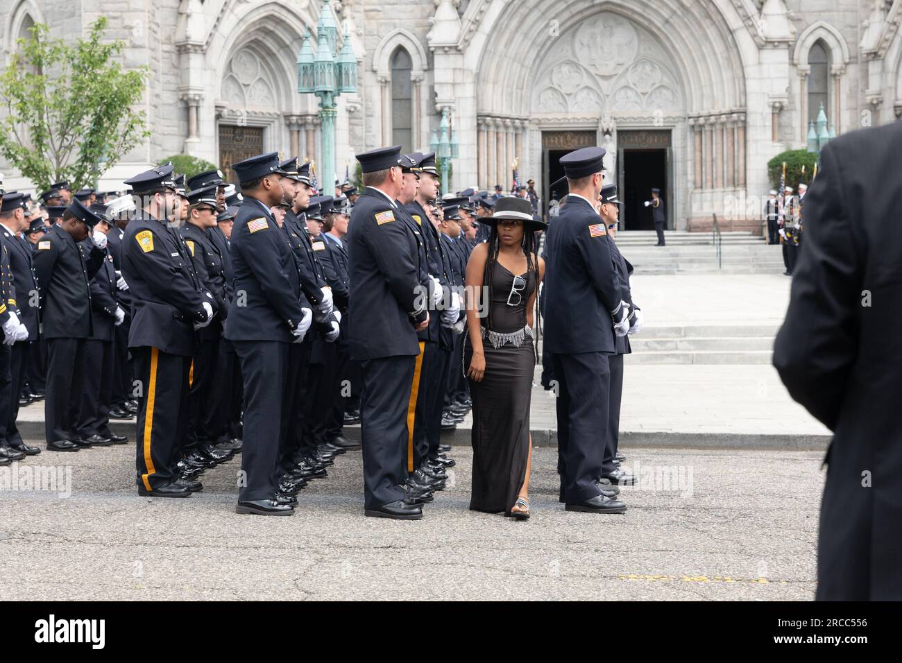 Newark, New Jersey, USA. 13. Juli 2023. Eine Frau geht durch die Parade, der Rest des Feuerwehrmanns, nach der Beerdigung des gefallenen Newark Feuerwehrmanns Augusto Acabou in der Basilika der Heiligen Herzen, nach seiner Beerdigung in Newark, New Jersey Acabou war einer von zwei Newark-Feuerwehrleuten, die bei dem Feuerlöschversuch auf dem italienischen Frachtschiff in Port Newark in Newark, NJ (Kreditbild: © Brian Branch Price/ZUMA Press Wire) fast eine Woche lang brannten. NUR REDAKTIONELLE VERWENDUNG! Nicht für den kommerziellen GEBRAUCH! Stockfoto