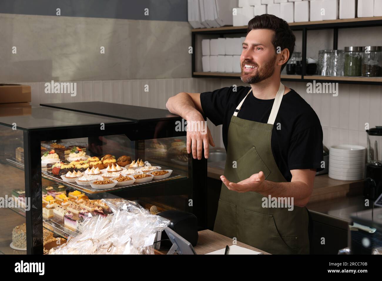 Portrait eines glücklichen Verkäufers an der Kasse in einer Bäckerei Stockfoto