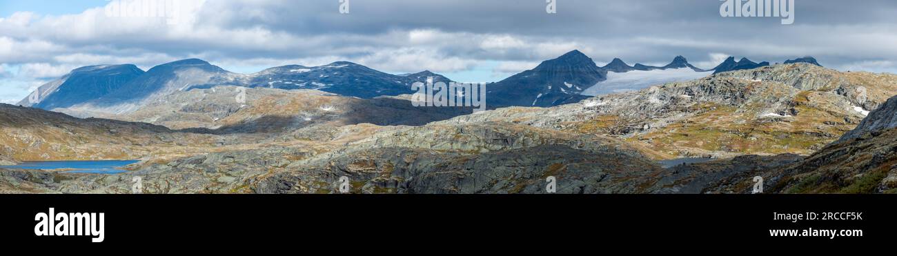 Die Sognefjell Road bietet einen atemberaubenden Blick auf den Mefjellet Mountain. Panoramablick auf zerklüftete Gipfel, tiefe Täler, rauschende Wasserfälle und das Stunnin Stockfoto