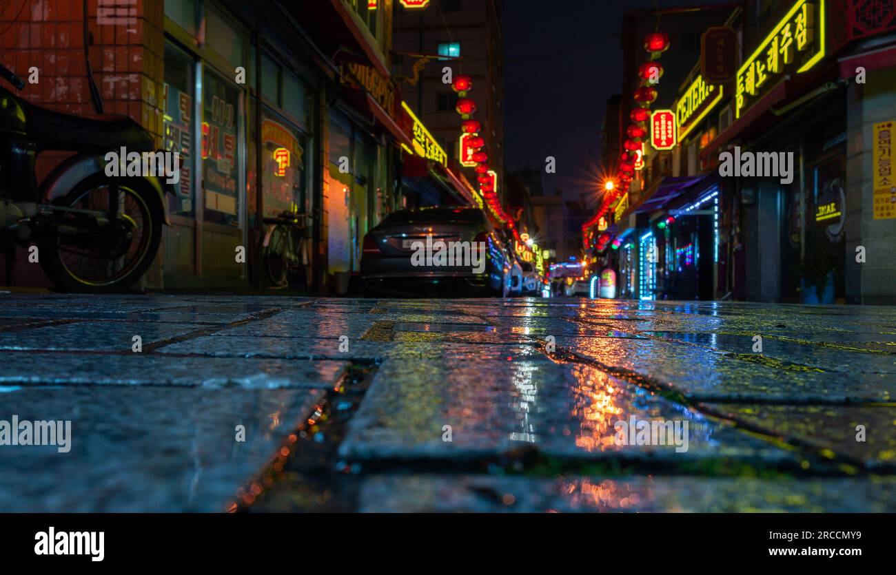 Busan, Südkorea - 19. März 2018: Blick auf die Straße mit farbenfroher Werbebeleuchtung und geparktem Auto, Stadtteil Busan bei Nacht. Selektiv für Stockfoto