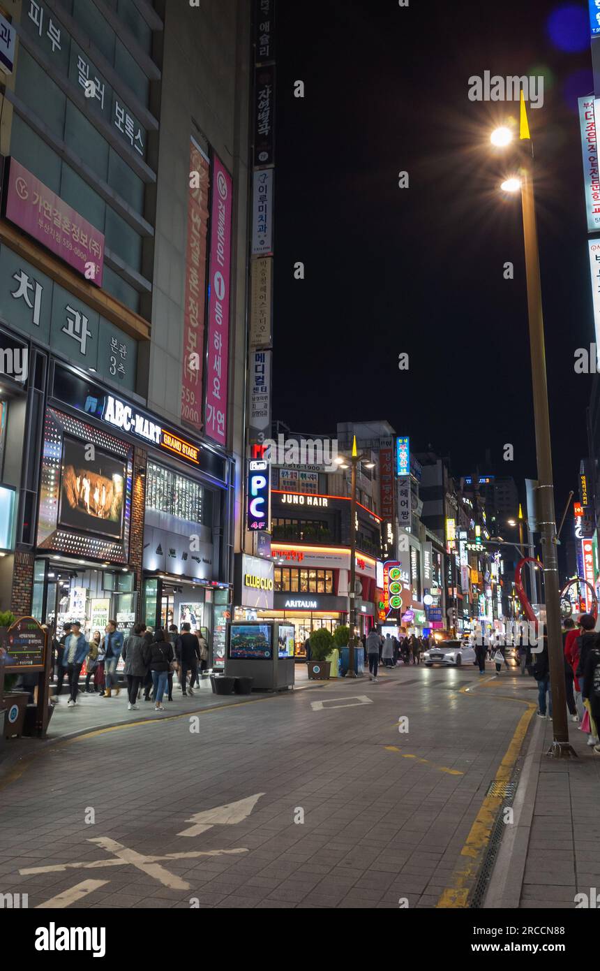 Busan, Südkorea - 19. März 2018: Vertikales Foto, Blick auf die Straße bei Nacht mit farbenfroher Neonwerbung, Autos und wandelnden Menschen Stockfoto
