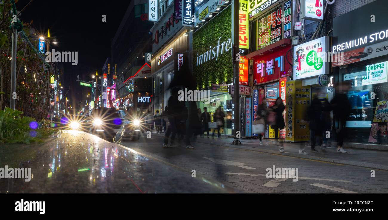 Busan, Südkorea - 19. März 2018: Panoramablick auf die Straße bei Nacht mit farbenfroher Neonwerbung, Autos und Spaziergängern Stockfoto