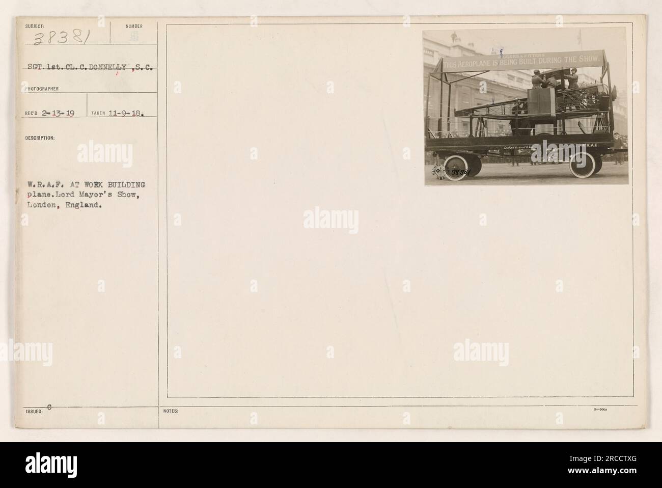 EIN W.R.A.F. Sergeant, identifiziert als Lieutenant Cl. C. Donnelly, wird gesehen, wie er eine Gruppe von Frauen bei der Arbeit fotografiert, während sie ein Flugzeug während der Lord Mayor's Show in London, England, zusammenbauen. Das Foto wurde am 9. November 1918 aufgenommen. Stockfoto