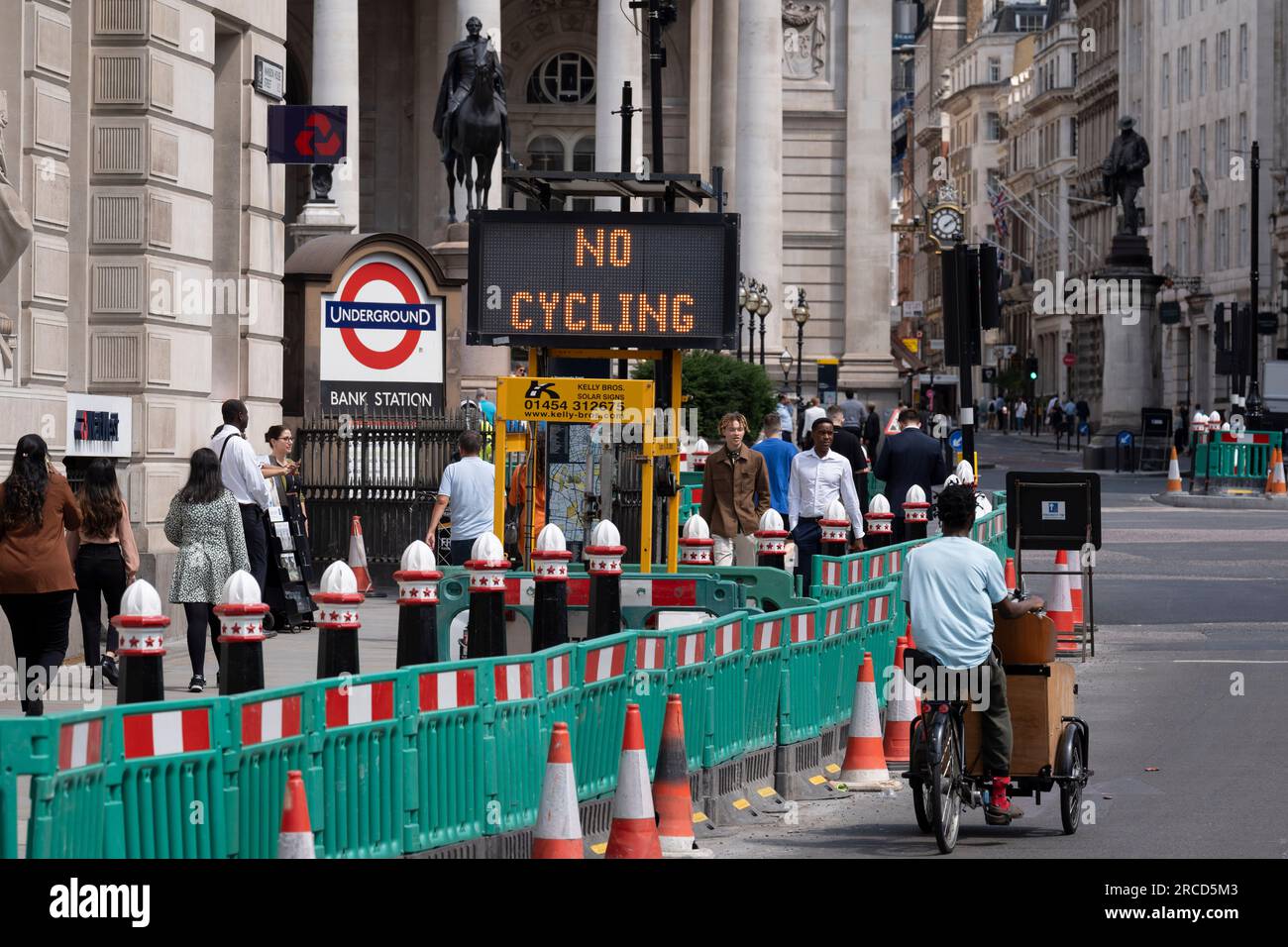 Ein Radfahrer fährt am 13. Juli 2023 in London, England, an einem Matrixschild vorbei, das Radfahrern mitteilt, dass sie auf der Straße in Richtung Threadneedle Street und Cornhill aufgrund des entgegenkommenden Verkehrs in der City of London, dem Finanzviertel der Hauptstadt, nicht radeln dürfen. Stockfoto