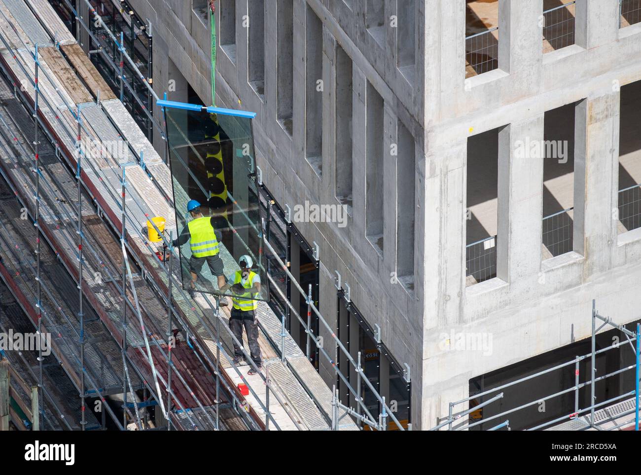 Glaser, die Fenster in einem Geschäftsgebäude montieren. Stockfoto