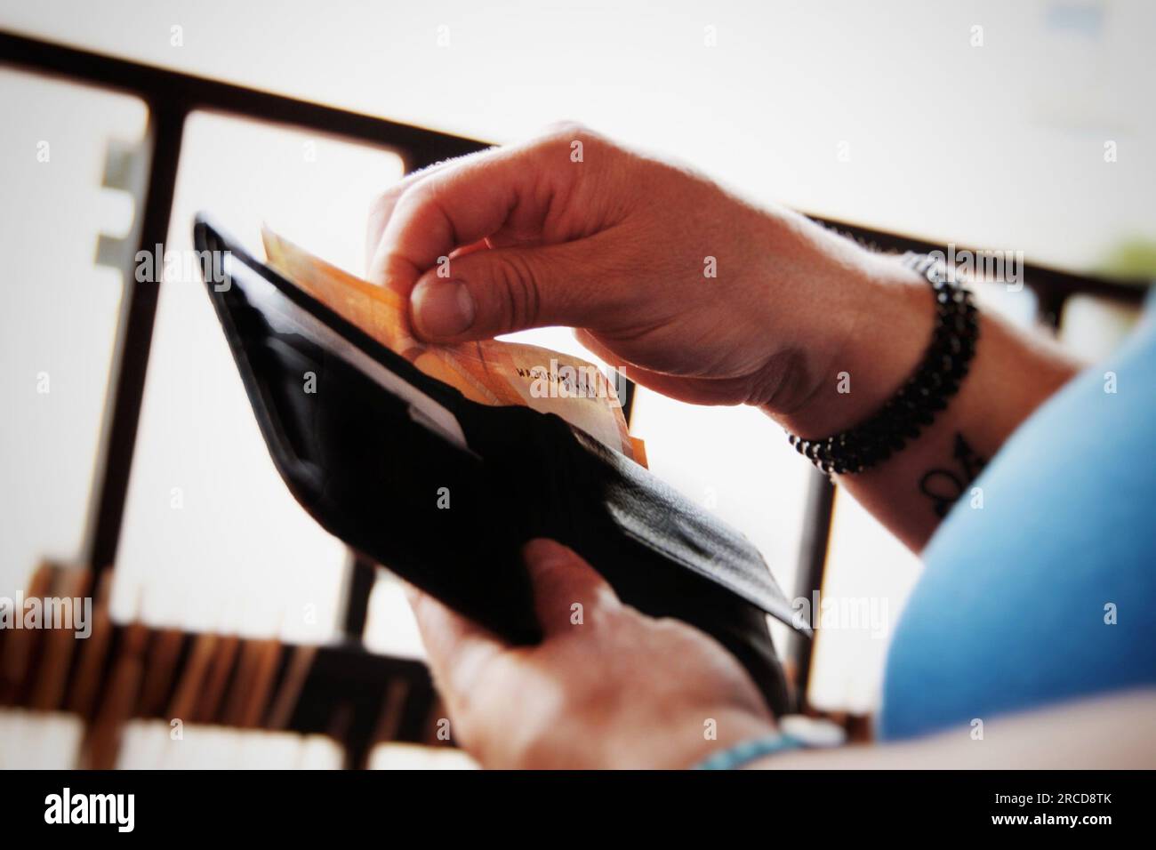 Person, die Geld aus seinem Portemonnaie nimmt. Stockfoto