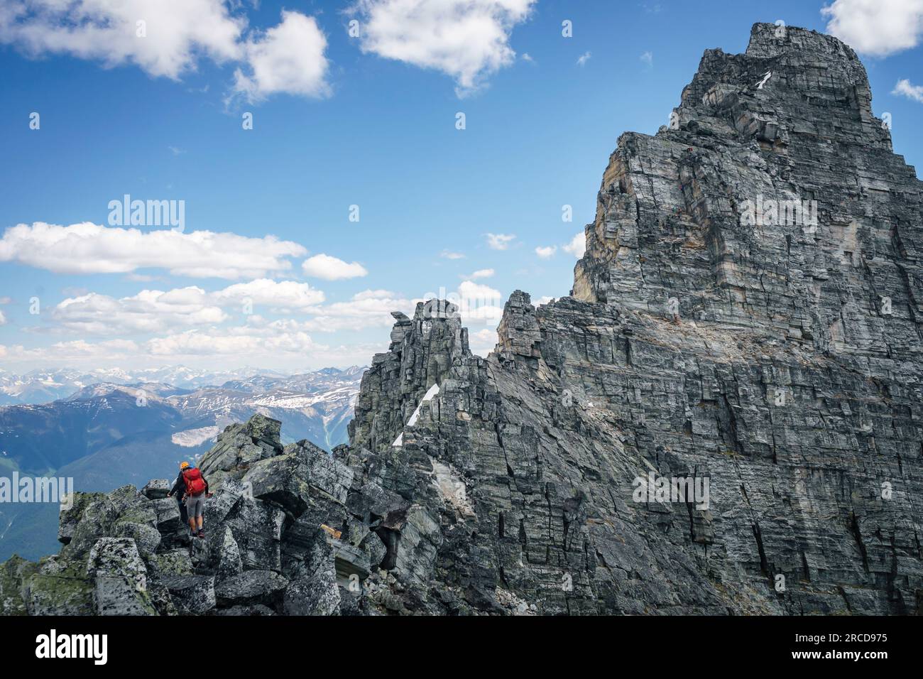 Männlicher Bergsteiger scheint am Fuße des großen Berges, BC, Kanada, klein zu sein Stockfoto