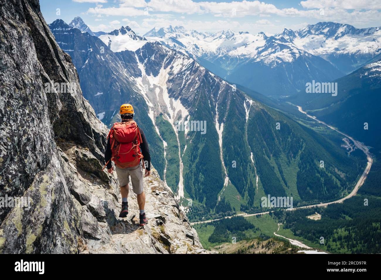 Männlicher Bergsteiger, der am Rand der Klippe spaziert, British Columbia Kanada Stockfoto