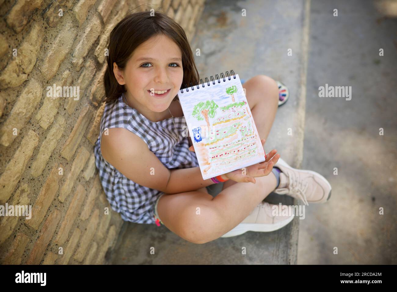 Ein achtjähriges Mädchen malt und malt in einem Park. Stockfoto