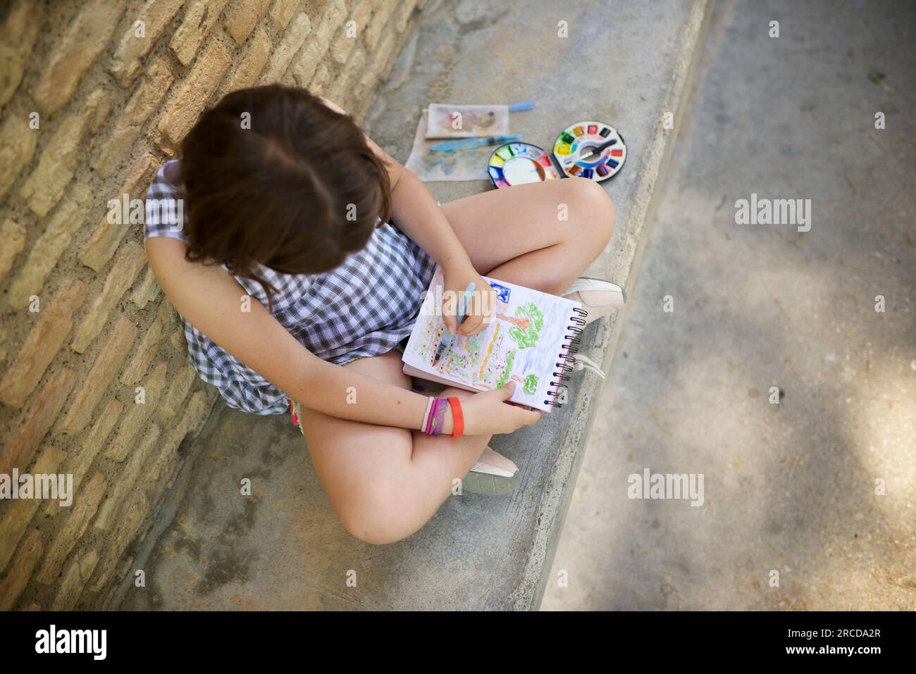 Ein achtjähriges Mädchen malt und malt in einem Park. Stockfoto