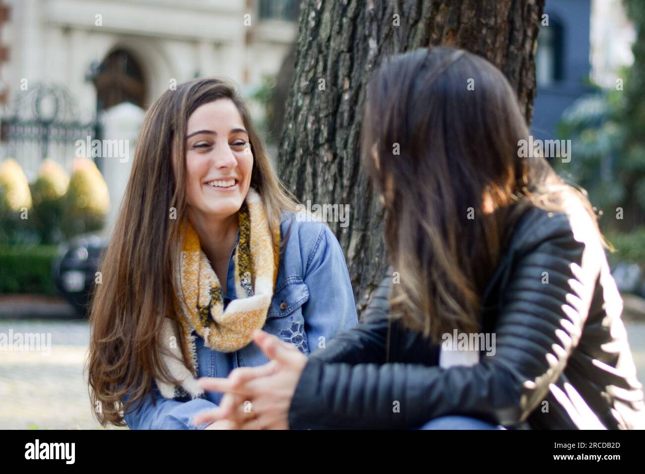 Glückliche Frauen, die auf der Straße sitzen Stockfoto