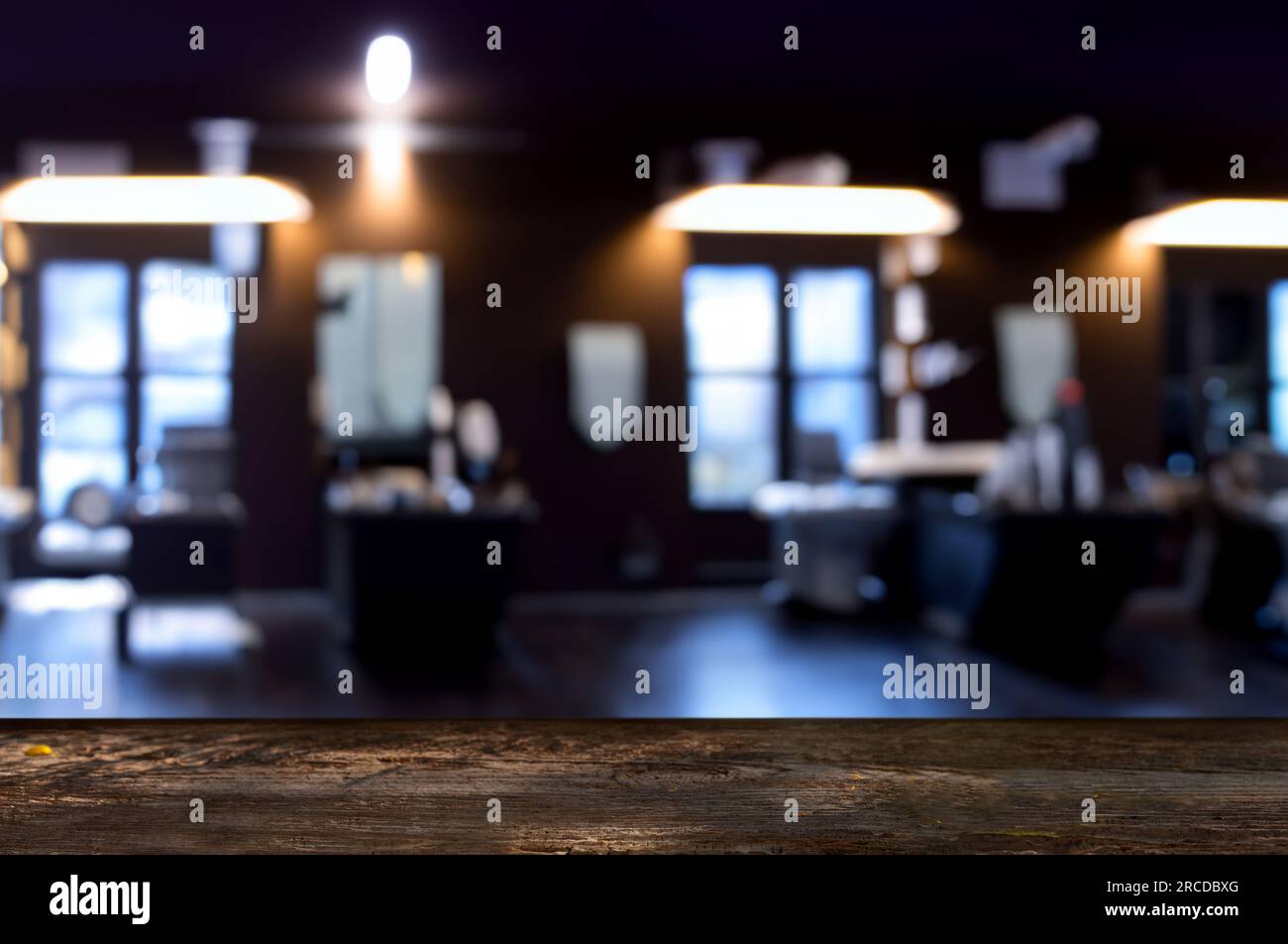 Holztisch mit Platz für Werbung, Hintergrund: Unscharfe Sicht auf den Friseursalon. Stockfoto