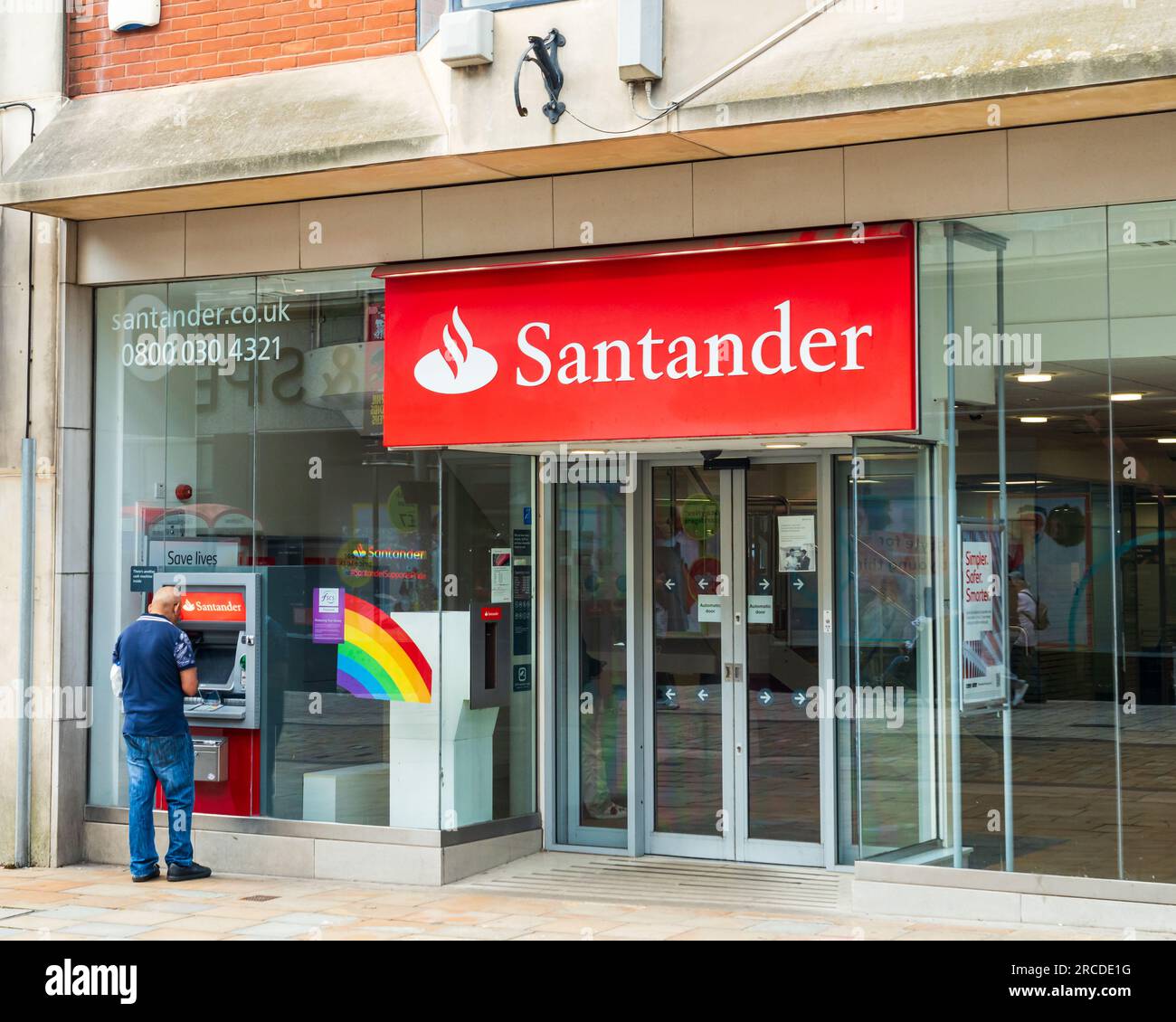 Wolverhampton, Vereinigtes Königreich - Juli 13 2023: Fronttage einer Santander Bank, einschließlich Person, die den Geldautomaten in Wolverhampton, Vereinigtes Königreich nutzt Stockfoto