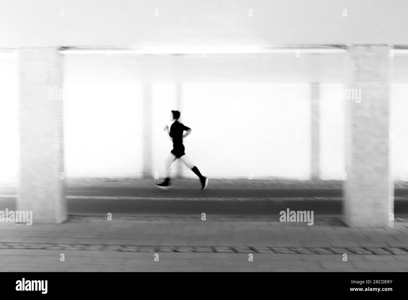 Kreatives Bild der Silhouette eines jungen Menschen beim Bewegungsunschärfe-Joggen Stockfoto