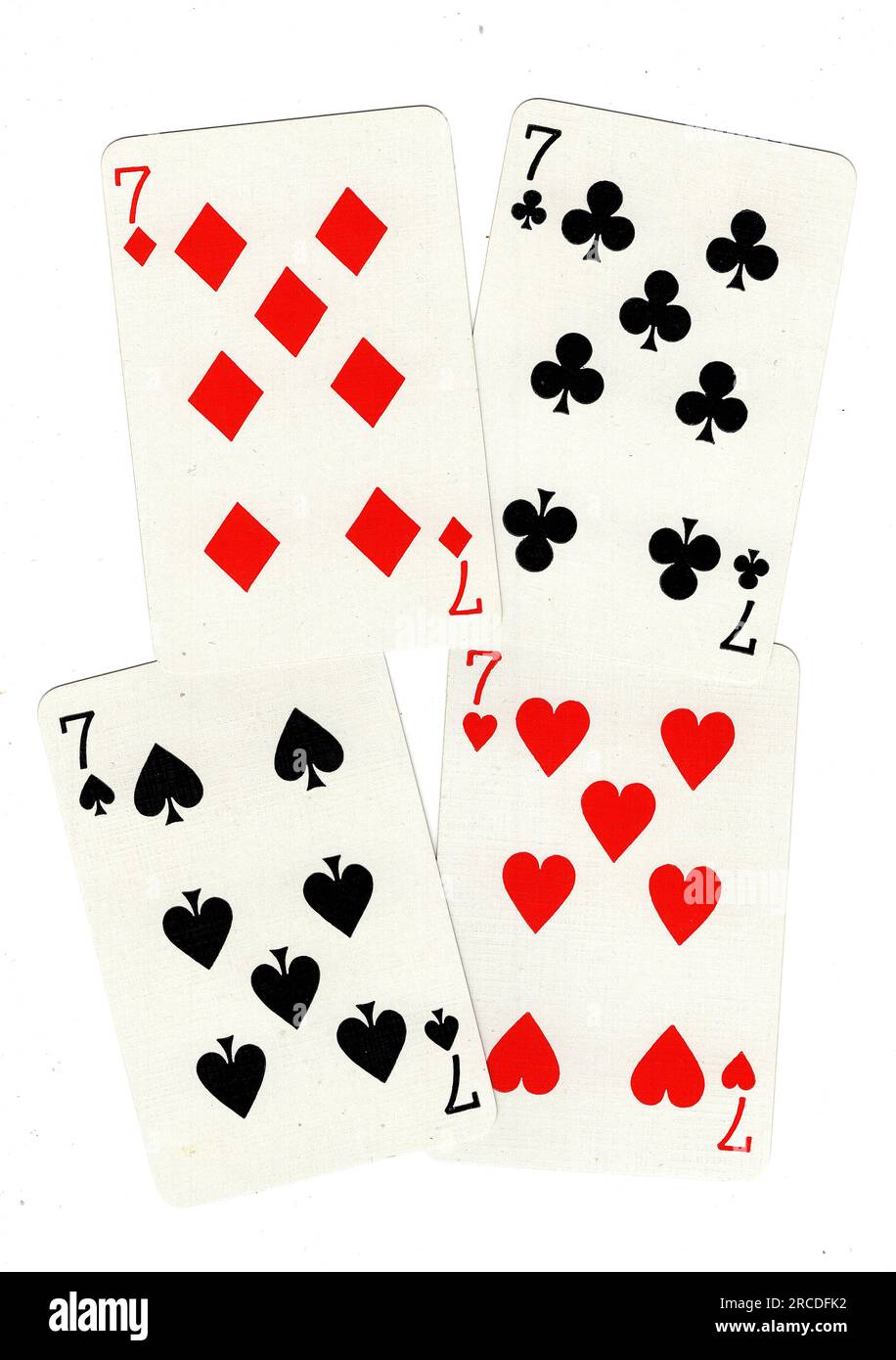 Vintage-Spielkarten mit vier Siebenen auf weißem Hintergrund. Stockfoto