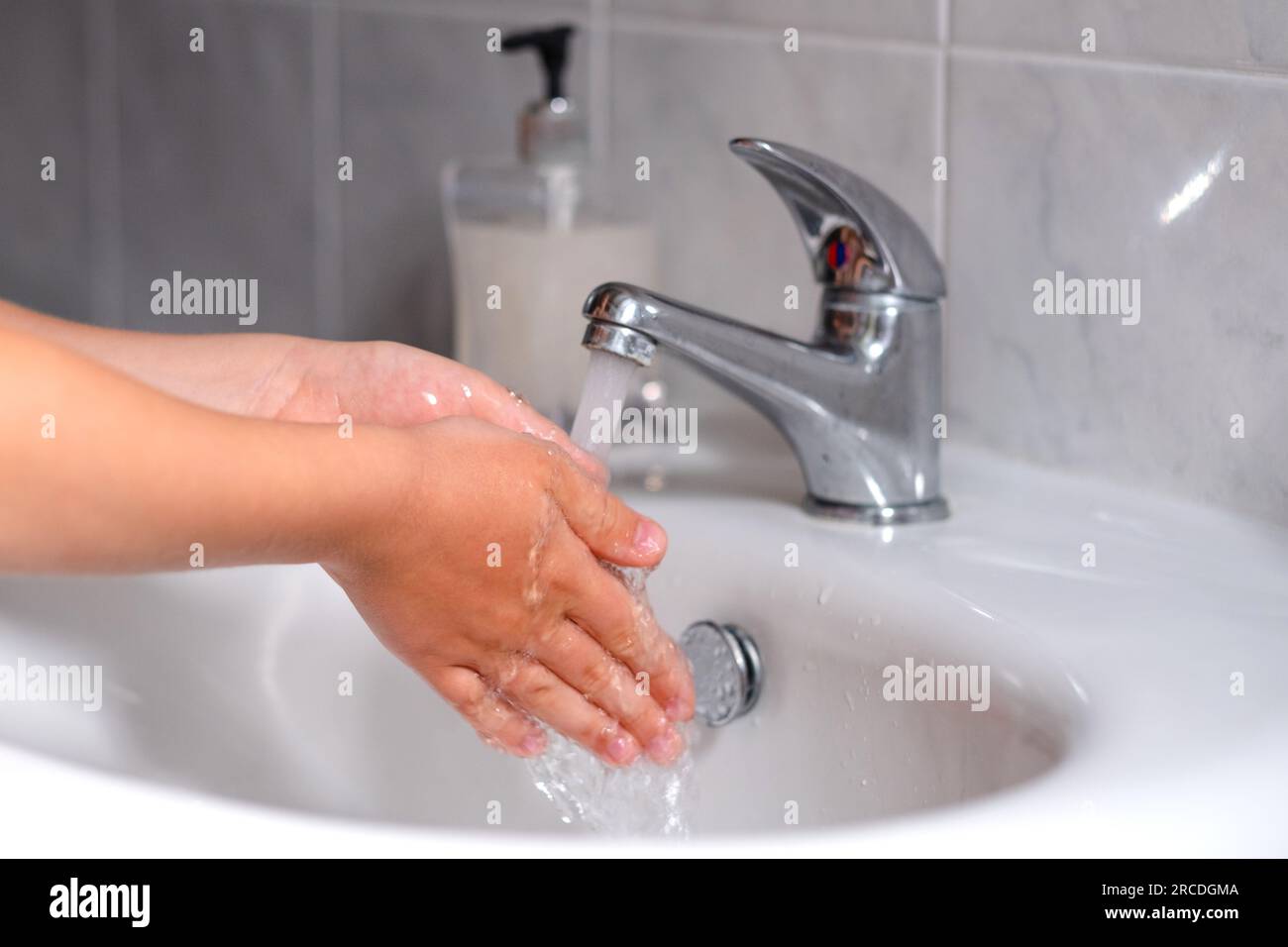 Ein Kind, das sich vor dem Essen im Bad die Hände wäscht. Hygiene, Sauberkeitskonzept. Umweltschutz und die Rettung des Planeten Stockfoto