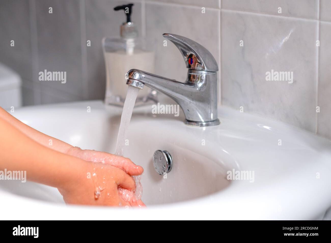 Ein Kind, das sich vor dem Essen im Bad die Hände wäscht. Hygiene, Sauberkeitskonzept. Umweltschutz und die Rettung des Planeten Stockfoto