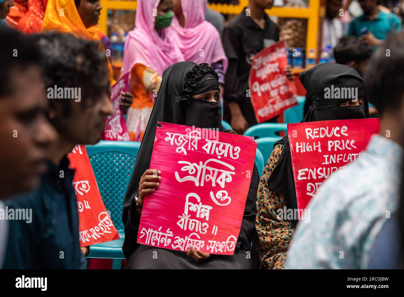 Dhaka, Bangladesch. 14. Juli 2023. Demonstranten halten während der Demonstration Plakate, auf denen ihre Meinung zum Ausdruck gebracht wird. Bangladesche Bekleidungsarbeiter protestieren und fordern eine Erhöhung des Mindestlohns von 25.000 BDT (230 USD) für Arbeitnehmer, da die steil ansteigende Inflation die Arbeiter in Schwierigkeiten bringt. (Foto: Sazzad Hossain/SOPA Images/Sipa USA) Guthaben: SIPA USA/Alamy Live News Stockfoto