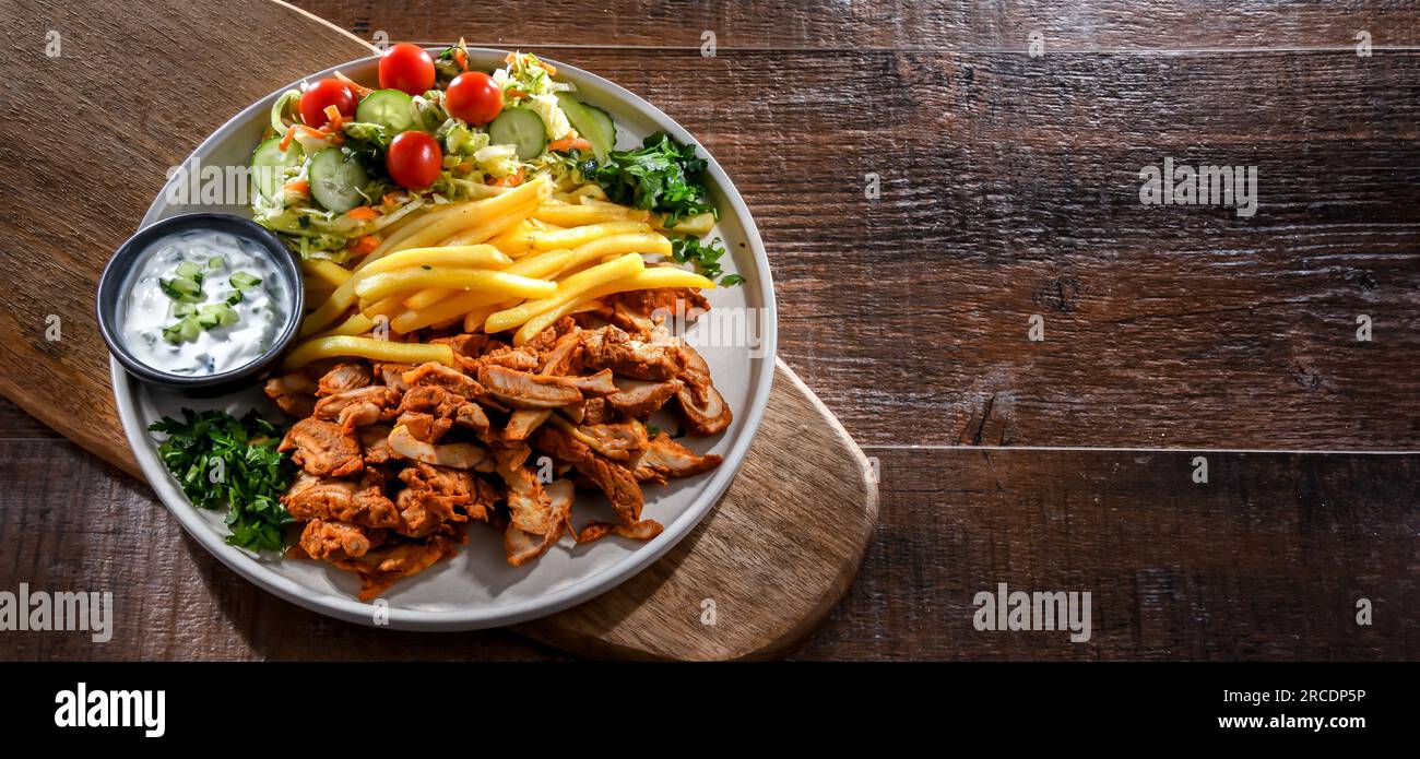 Kebab serviert mit pommes Frites, Gemüsesalat und Tzatziki Stockfoto