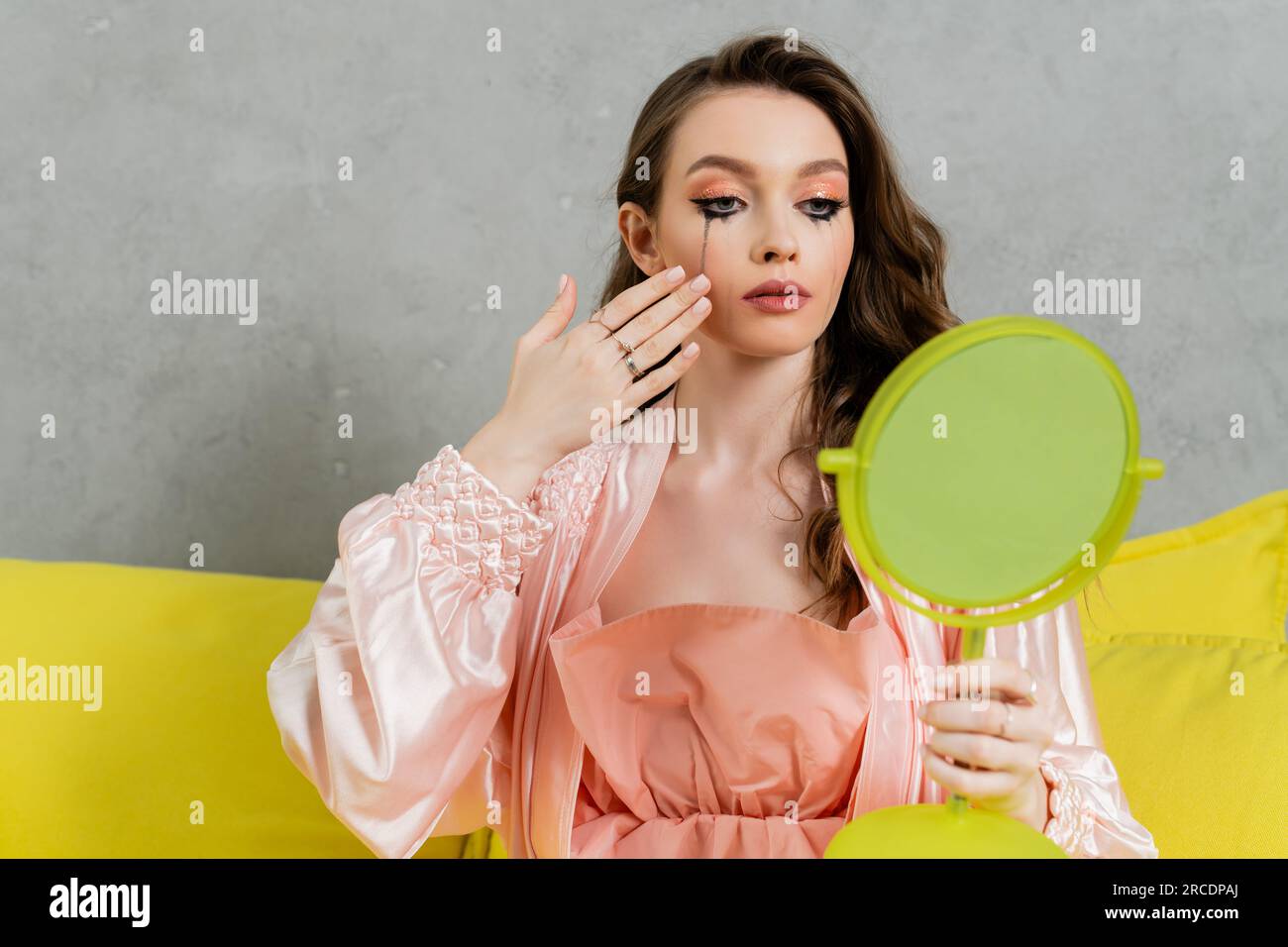 Depression, traurige Frau mit verschmierter Mascara, die sich wie eine Puppe benimmt und die Hand nahe am Gesicht hält, Hausfrau mit weinenden Augen, die in den Spiegel schaut, sich einsam fühlt Stockfoto
