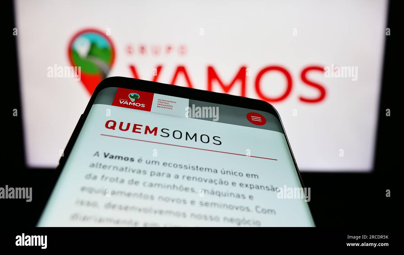 Smartphone mit Website des brasilianischen Lkw-Vermietungsunternehmens Grupo Vamos auf dem Bildschirm vor dem Unternehmenslogo. Fokus auf oberer linker Seite des Telefondisplays. Stockfoto