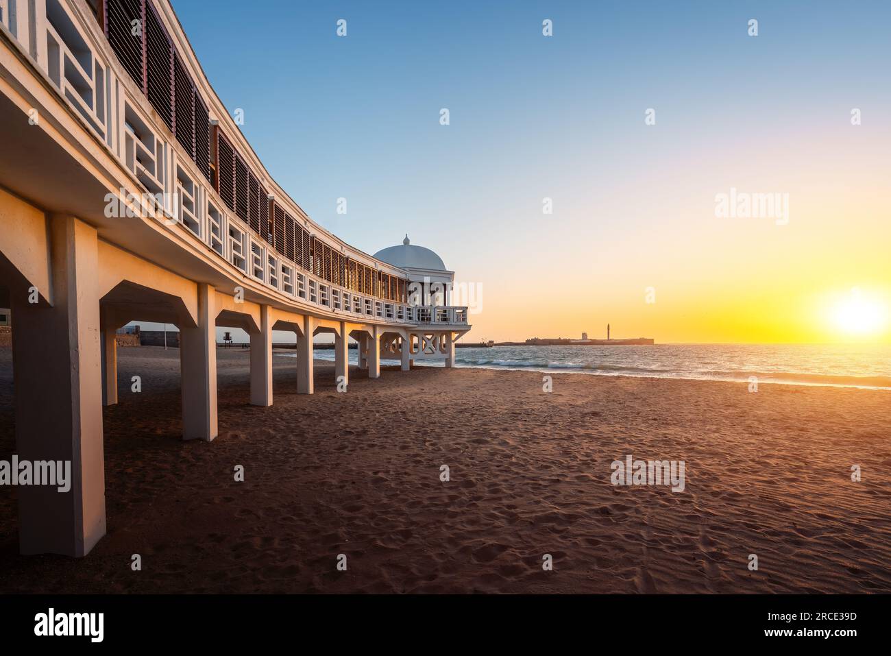 La Caleta Beach, Balneario de la Palma Gebäude und Schloss von San Sebastian bei Sonnenuntergang - Cadiz, Andalusien, Spanien Stockfoto