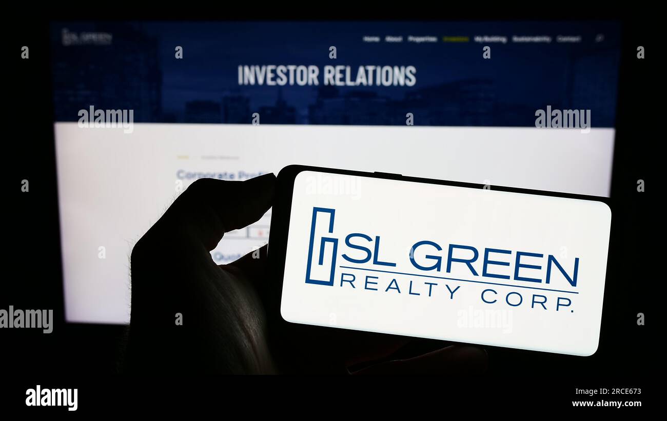Person, die ein Handy mit dem Logo der amerikanischen Immobilienfirma SL Green Realty Corp. Auf dem Bildschirm vor der Webseite hält. Konzentrieren Sie sich auf das Display des Telefons. Stockfoto