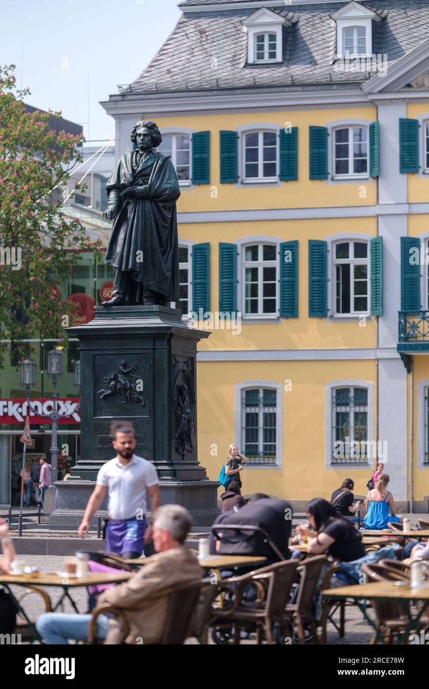 Bonn, Deutschland - 22. Mai 2023 : Blick auf die Statue von Ludwig van Beethoven, ein Bistro-Restaurant und das Deutsche Postgebäude im Hintergrund in Bonn Stockfoto