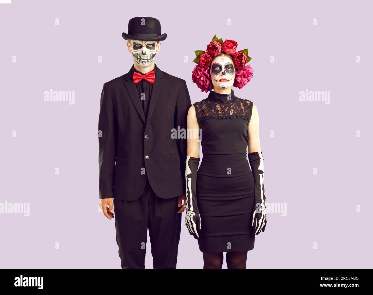 Zombie-Liebesgeschichte. Ein Paar am Maskentag der Toten-Beerdigungskostüme, die nebeneinander stehen Stockfoto
