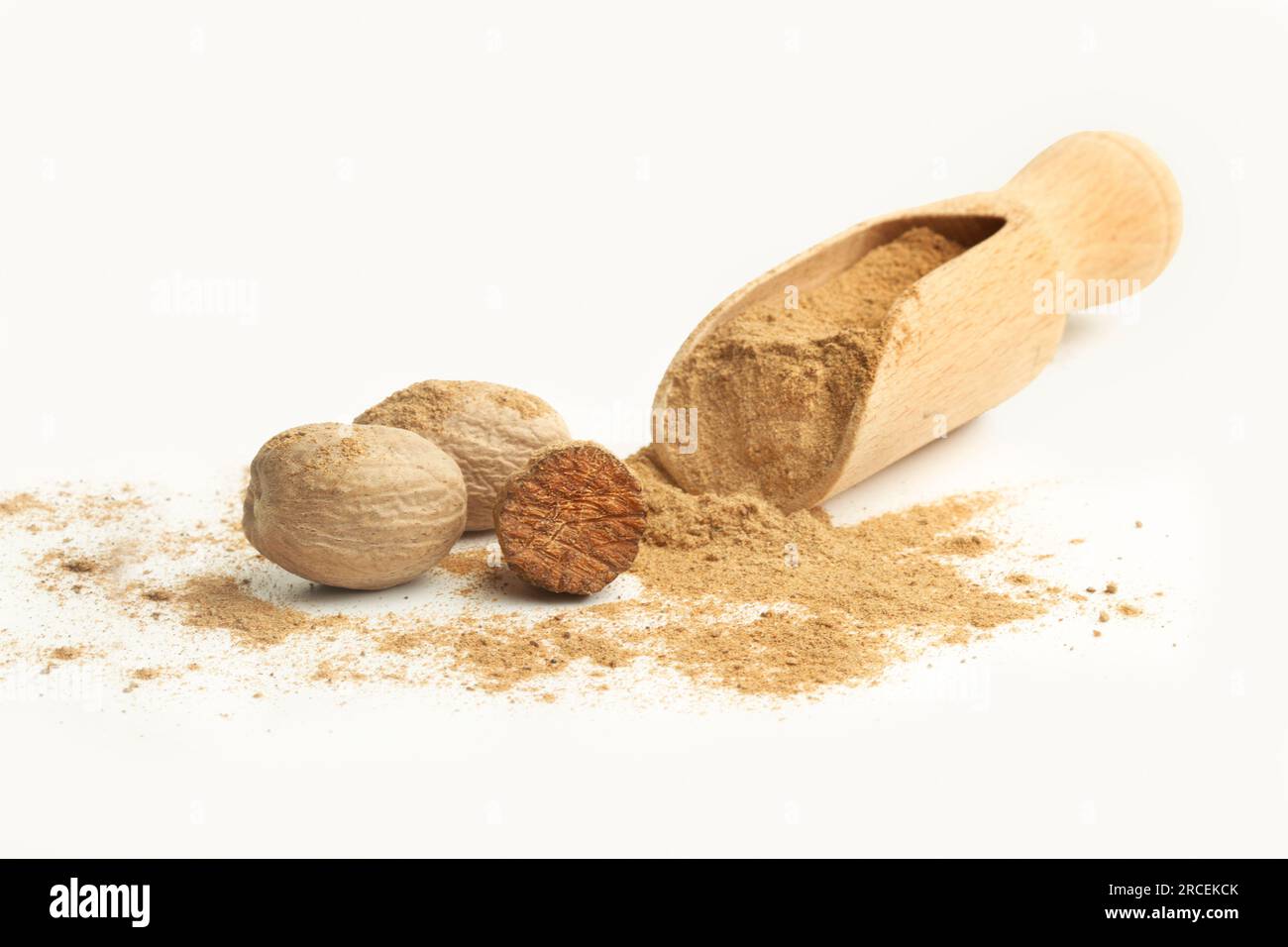 Muskatnuss und Muskatnuss in Pulverform auf einer Holzschaufel auf weißem Hintergrund mit Kopierbereich Stockfoto